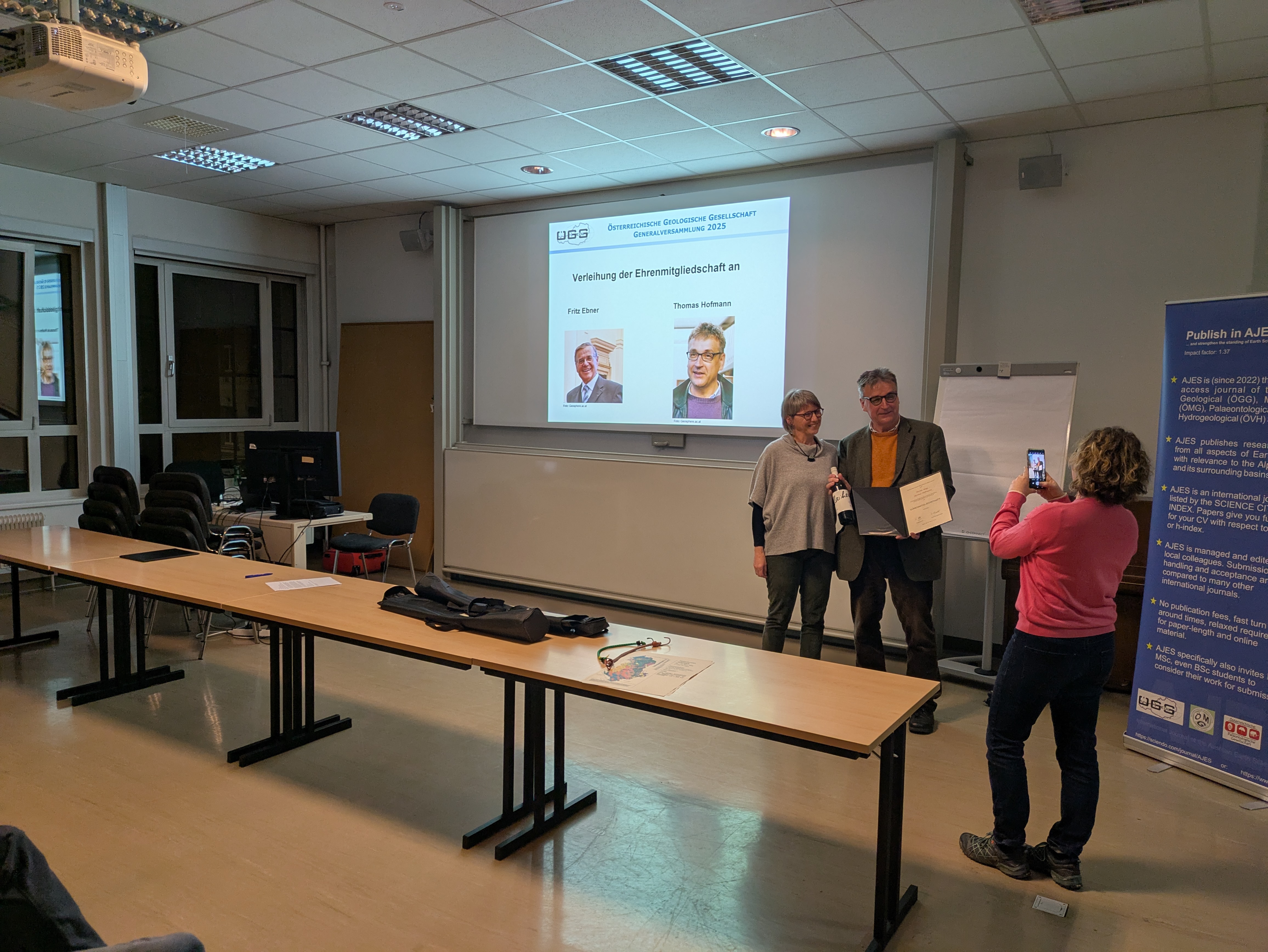 Zwei Personen vor einer Leinwand werden fotografiert.