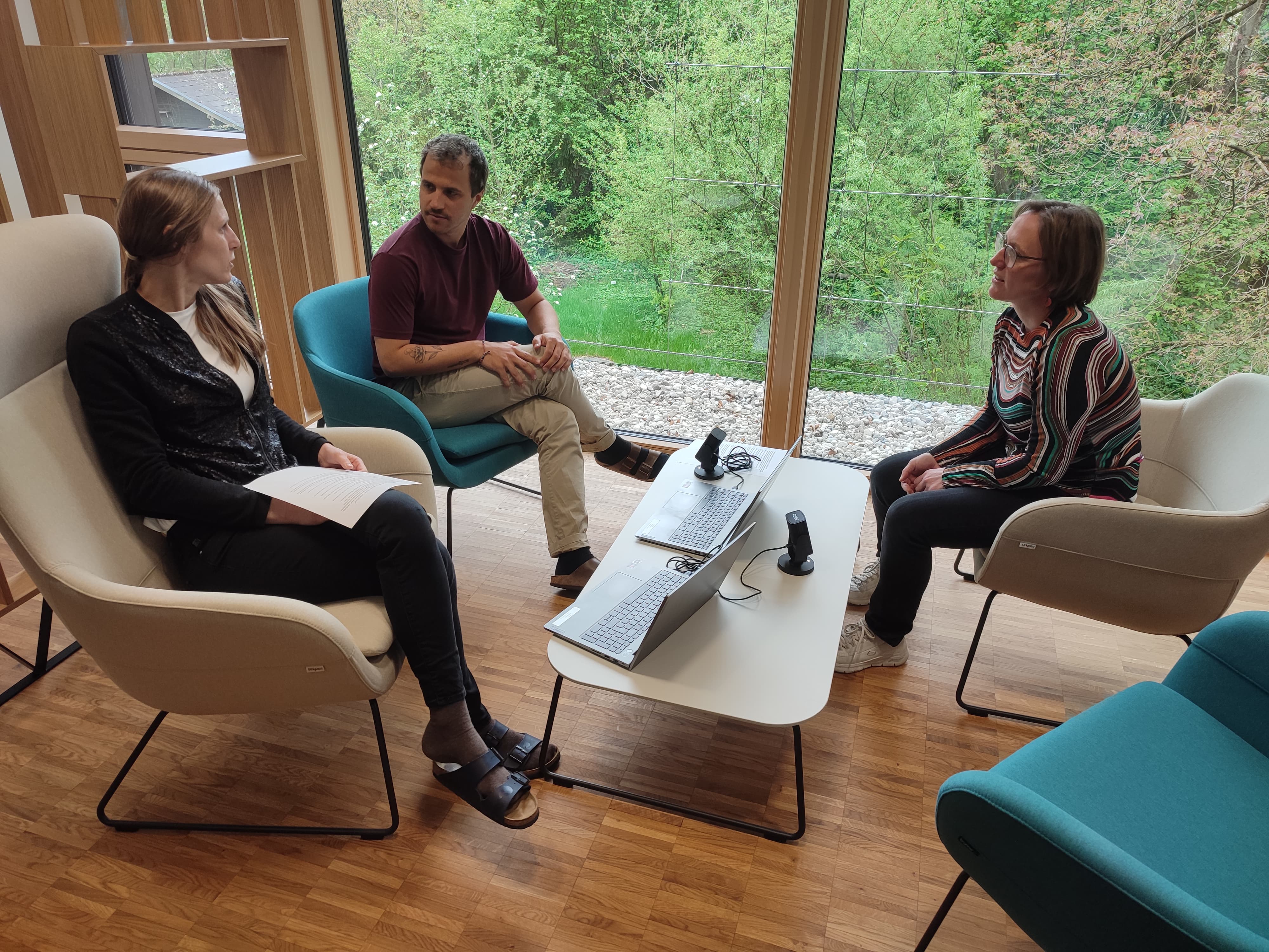 Two women and a man are sitting round a table.