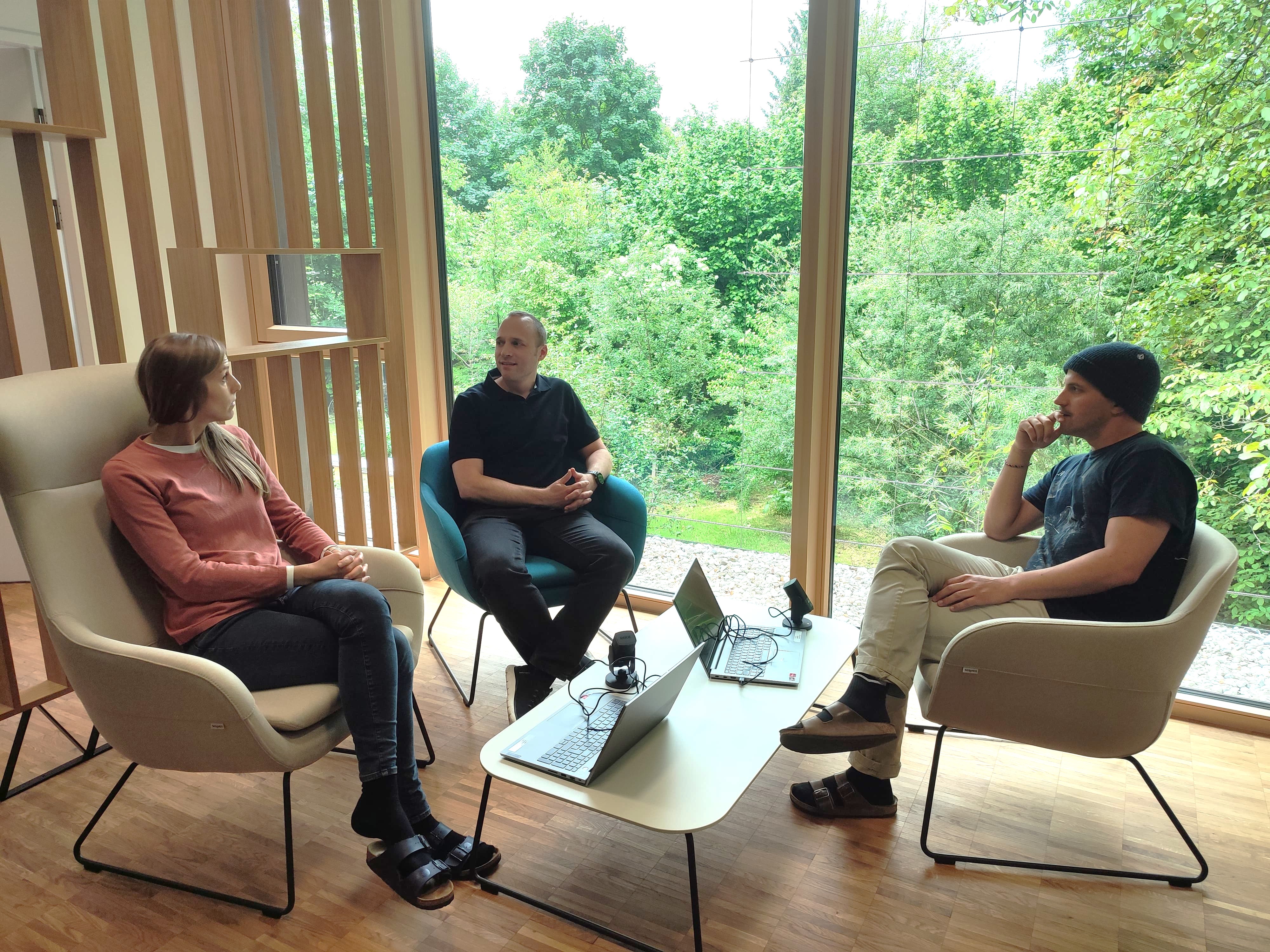 3 Personen sitzen an einem Tisch
