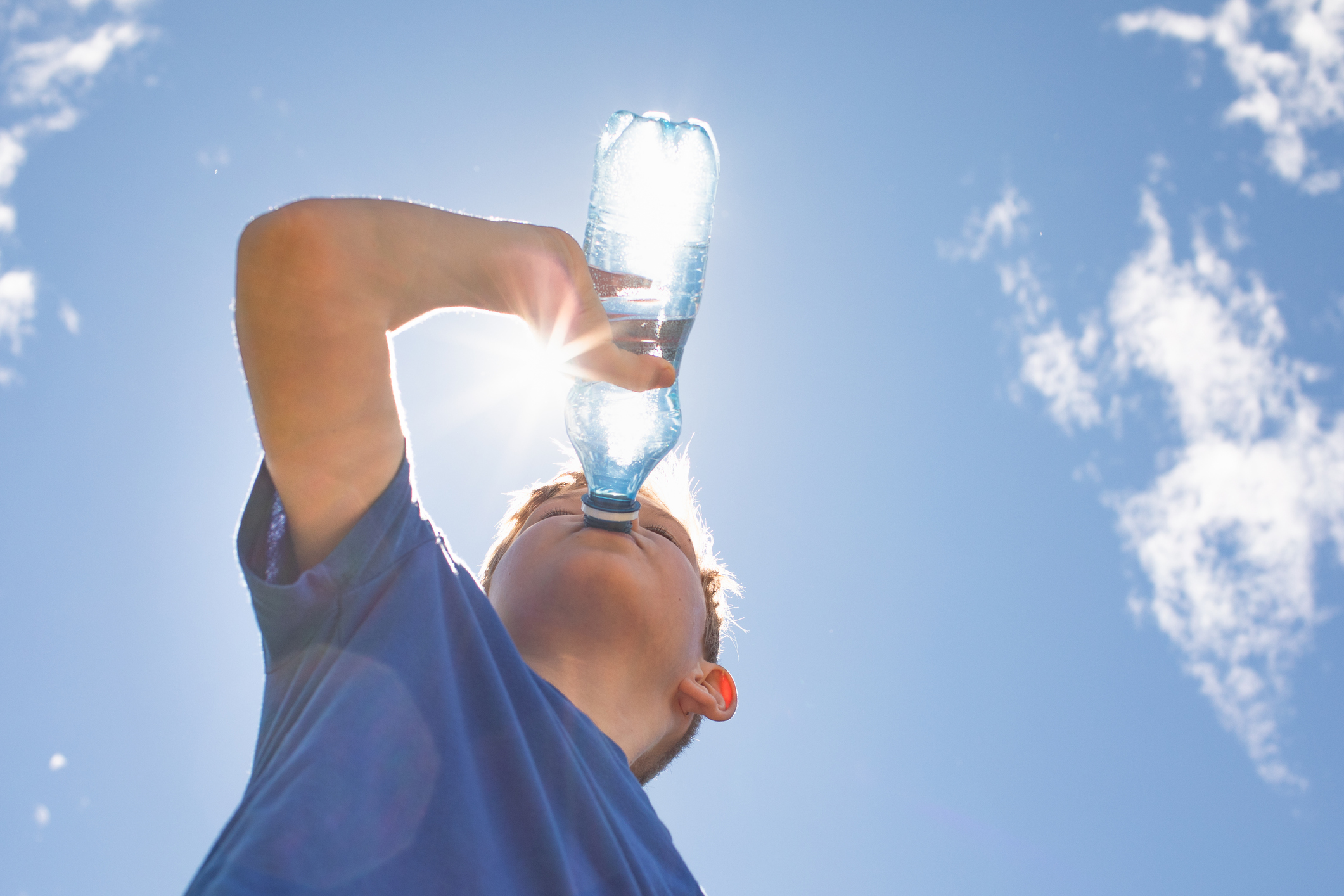Kind mit Wasserflasche bei heißem Wetter
