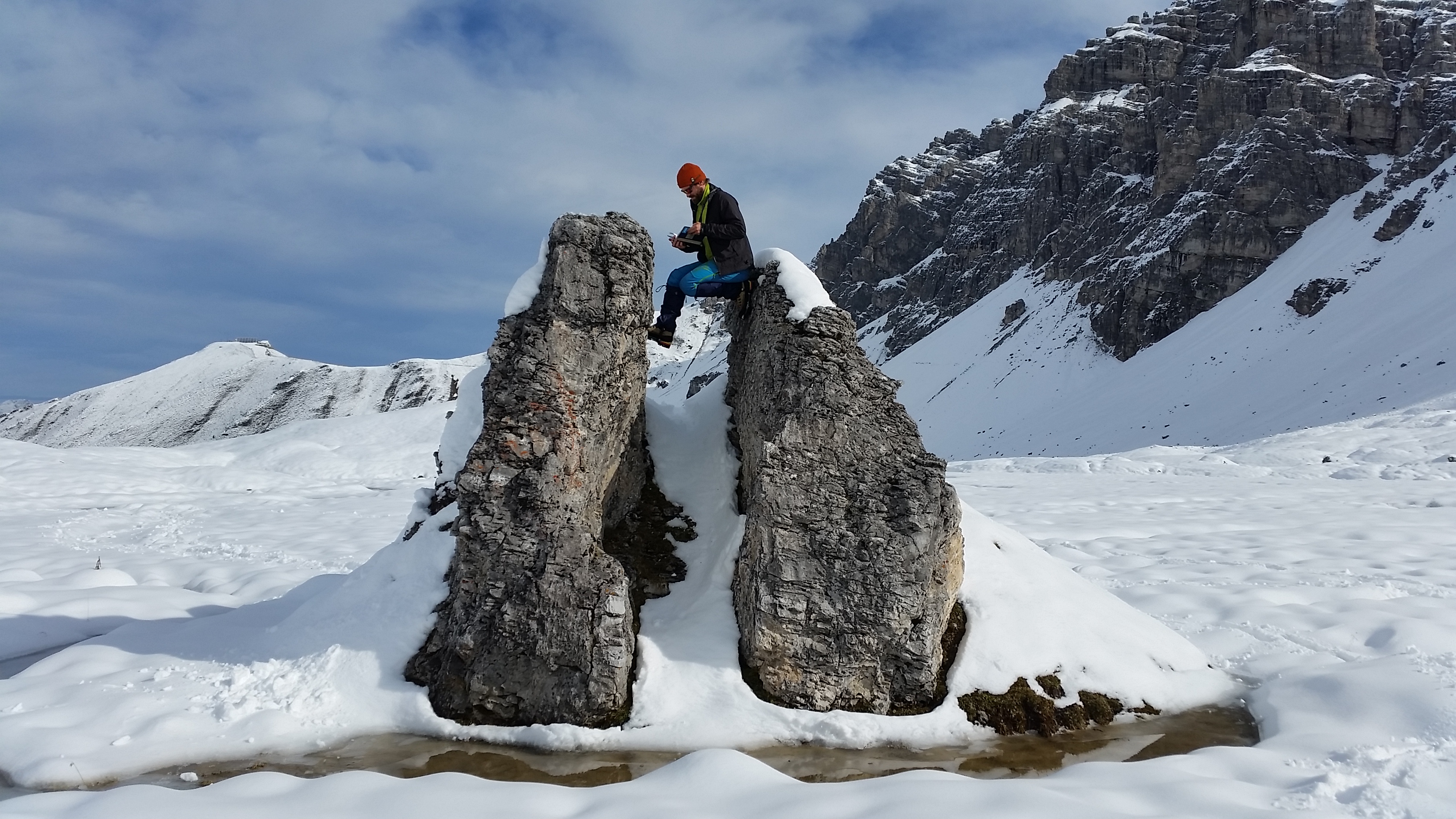 Ein Mann sitzt auf einem Felsen.